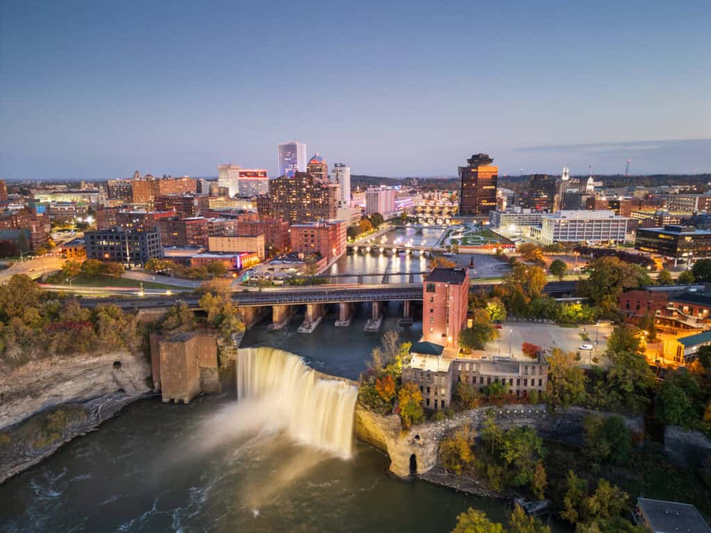 Rochester, New York, USA cityscape on the Genesee River and High Falls at twilight